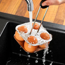 В такой металлической подставке яйца надёжно фиксируются. Охлаждаем яйца под струёй холодной воды.